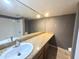 Bathroom featuring granite countertops, framed mirror, and a shower with a white tile surround at 1702 W Tuckey Ln # 209, Phoenix, AZ 85015