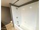 Bathroom features a shower and tub combo with tiled surround, silver hardware, and neutral walls at 1702 W Tuckey Ln # 209, Phoenix, AZ 85015