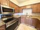 Well-equipped kitchen featuring stainless appliances, granite countertops, and tile accents at 1702 W Tuckey Ln # 209, Phoenix, AZ 85015