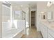 Bright bathroom showcasing double sinks with quartz counters, a tub, and glass-enclosed shower at 19033 W Rose Ln, Waddell, AZ 85355