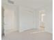 Bright bedroom with neutral carpet, white walls, double door closet and an open bathroom entrance at 19033 W Rose Ln, Waddell, AZ 85355