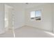 Bright bedroom featuring neutral carpet, white walls, and an open door to the bathroom at 19033 W Rose Ln, Waddell, AZ 85355