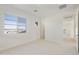 Bright bedroom features neutral carpet, white walls, and a large window with neighborhood view at 19033 W Rose Ln, Waddell, AZ 85355