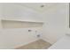 Bright laundry room with overhead shelf, utility connections, and neutral flooring, ready for appliances and organization at 19033 W Rose Ln, Waddell, AZ 85355