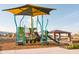 Community playground with covered picnic pavilion and seating area with nearby walking path at 19033 W Rose Ln, Waddell, AZ 85355