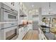 Sleek kitchen boasts stainless steel appliances, custom cabinets with glass doors, and an island with bar seating at 19420 W San Juan Ave, Litchfield Park, AZ 85340