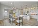 Spacious dining area with a wood table set for six, open to a bright kitchen featuring an island with bar seating at 19420 W San Juan Ave, Litchfield Park, AZ 85340
