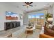 Cozy living room with a ceiling fan, plush seating, modern decor, and sliding glass doors to the outdoor patio at 19420 W San Juan Ave, Litchfield Park, AZ 85340