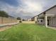 Spacious backyard featuring a large lawn, block fencing, and covered patio area perfect for outdoor entertaining at 19432 W Morning Glory Dr, Buckeye, AZ 85326