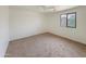Bright bedroom with a ceiling fan, plush carpet, and a window at 19432 W Morning Glory Dr, Buckeye, AZ 85326