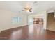 Bright living room with hardwood floors, ceiling fan, large windows, and an open layout at 19432 W Morning Glory Dr, Buckeye, AZ 85326