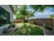 Well-maintained backyard with lush green grass, mature trees, and stone landscaping along the brick fence at 1970 E Yellowstone Pl, Chandler, AZ 85249
