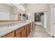 Bright bathroom featuring dual sinks, granite counters, and a mirrored closet revealing a large bathtub with glass block at 1970 E Yellowstone Pl, Chandler, AZ 85249