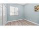 Bedroom featuring light blue walls, light laminate floors, and a window, offering a calming aesthetic at 1970 E Yellowstone Pl, Chandler, AZ 85249