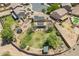 Aerial view of a home showcasing a spacious backyard with a trampoline, garden beds, a patio, and solar panels at 21188 N Duncan Dr, Maricopa, AZ 85138
