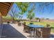Charming backyard patio with wicker furniture, perfect for enjoying outdoor dining and the serene landscape at 21188 N Duncan Dr, Maricopa, AZ 85138