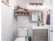 Bathroom with a decorative mirror, light fixture, toilet, and storage shelves at 21188 N Duncan Dr, Maricopa, AZ 85138