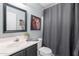 Bathroom with a single vanity, with a black frame mirror, a black shower curtain rod, and a white toilet at 21188 N Duncan Dr, Maricopa, AZ 85138