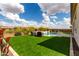 Lush backyard featuring artificial turf, a stunning pool with a waterfall feature, and ample seating areas at 24035 N 171St Dr, Surprise, AZ 85387