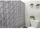 Cozy bathroom with leafy patterned shower curtain, toilet and decorative wall hangings at 24035 N 171St Dr, Surprise, AZ 85387