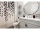Bright bathroom featuring a vanity and toilet with a decorative shower curtain at 24035 N 171St Dr, Surprise, AZ 85387