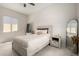 Neutral bedroom featuring a wooden bed frame and furnishings, complemented by natural light at 24035 N 171St Dr, Surprise, AZ 85387