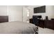 Bedroom with a large TV and desk, featuring neutral tones and carpet at 24035 N 171St Dr, Surprise, AZ 85387
