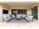 Inviting covered patio with comfortable seating, ceiling fan, and sliding doors to the living area at 24035 N 171St Dr, Surprise, AZ 85387