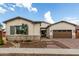 Charming single-story home with stone accents, a well-manicured yard, and a two-car garage at 24035 N 171St Dr, Surprise, AZ 85387