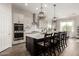 This kitchen features a kitchen island with chairs, modern appliances, and white cabinetry at 24035 N 171St Dr, Surprise, AZ 85387