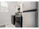 Well-lit laundry room featuring modern washer and dryer, cabinets, and sleek stainless steel refrigerator at 24035 N 171St Dr, Surprise, AZ 85387