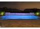 Night view of a backyard pool with a cascading waterfall feature and illuminated water at 24035 N 171St Dr, Surprise, AZ 85387
