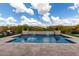 Inviting pool area with artificial turf, a soothing waterfall feature, and comfortable patio furniture at 24035 N 171St Dr, Surprise, AZ 85387