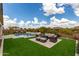 Lush backyard features artificial turf, a stunning pool with a waterfall feature, and ample seating areas at 24035 N 171St Dr, Surprise, AZ 85387