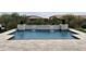 Backyard swimming pool featuring a tiled waterfall feature and travertine tile decking at 24035 N 171St Dr, Surprise, AZ 85387