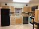 Functional kitchen featuring light wood cabinets, tile countertops, and a black appliance suite at 2405 N Eastwood Way, Mesa, AZ 85215