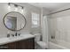 Updated bathroom features a shower/tub combo, modern vanity with dark wood cabinetry, and round mirror at 2562 E Los Alamos St, Gilbert, AZ 85295