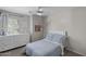 Bright bedroom features a ceiling fan, white dresser, and large window overlooking the landscaped yard at 2562 E Los Alamos St, Gilbert, AZ 85295