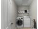 Modern laundry room featuring a side-by-side washer and dryer, storage shelf, and convenient access at 2562 E Los Alamos St, Gilbert, AZ 85295