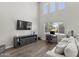 Comfortable living area featuring wood flooring, media console, and a cozy sofa at 2562 E Los Alamos St, Gilbert, AZ 85295