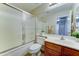 Well-lit bathroom featuring a shower-tub combination, wood vanity, and neutral-toned walls at 25729 W St Charles Ct, Buckeye, AZ 85326
