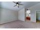 Carpeted bedroom features ceiling fan, and doorway to an ensuite bathroom at 25729 W St Charles Ct, Buckeye, AZ 85326