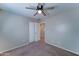 Carpeted bedroom with ceiling fan and doorway to an ensuite bathroom at 25729 W St Charles Ct, Buckeye, AZ 85326