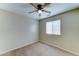 Carpeted bedroom features neutral walls, a ceiling fan, and a large window at 25729 W St Charles Ct, Buckeye, AZ 85326