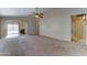 Large living space with neutral carpet, ceiling fan, and easy access to the outdoor patio at 25729 W St Charles Ct, Buckeye, AZ 85326