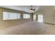 Spacious living area offering neutral carpeting, a ceiling fan, and sliding doors to the patio at 25729 W St Charles Ct, Buckeye, AZ 85326
