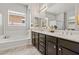 Bathroom featuring a double vanity, soaking tub, and a separate glass-enclosed shower at 2604 W Balao Dr, Phoenix, AZ 85085
