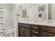 Bathroom featuring double sinks, dark wood cabinets, and a combined tub and shower at 2604 W Balao Dr, Phoenix, AZ 85085