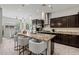 Modern kitchen with granite island, pendant lighting, stainless steel appliances, and dark cabinets is perfect for cooking at 2604 W Balao Dr, Phoenix, AZ 85085