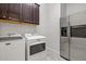 Functional laundry room featuring a washer, dryer, cabinets, and a stainless steel refrigerator at 2604 W Balao Dr, Phoenix, AZ 85085